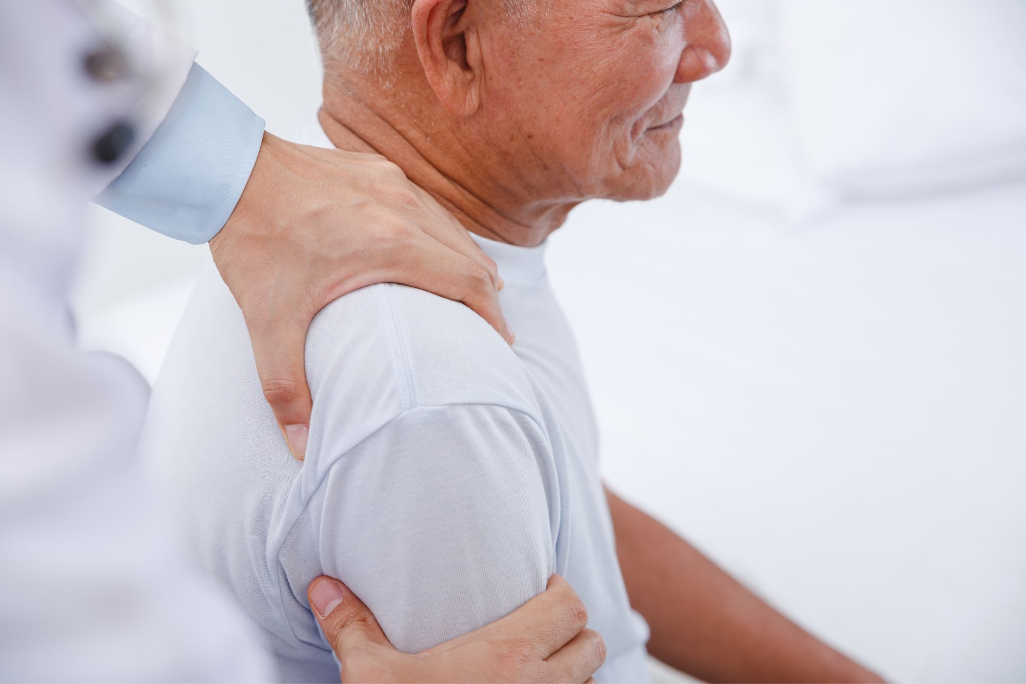 elderly man with physical therapist working on shoulder
